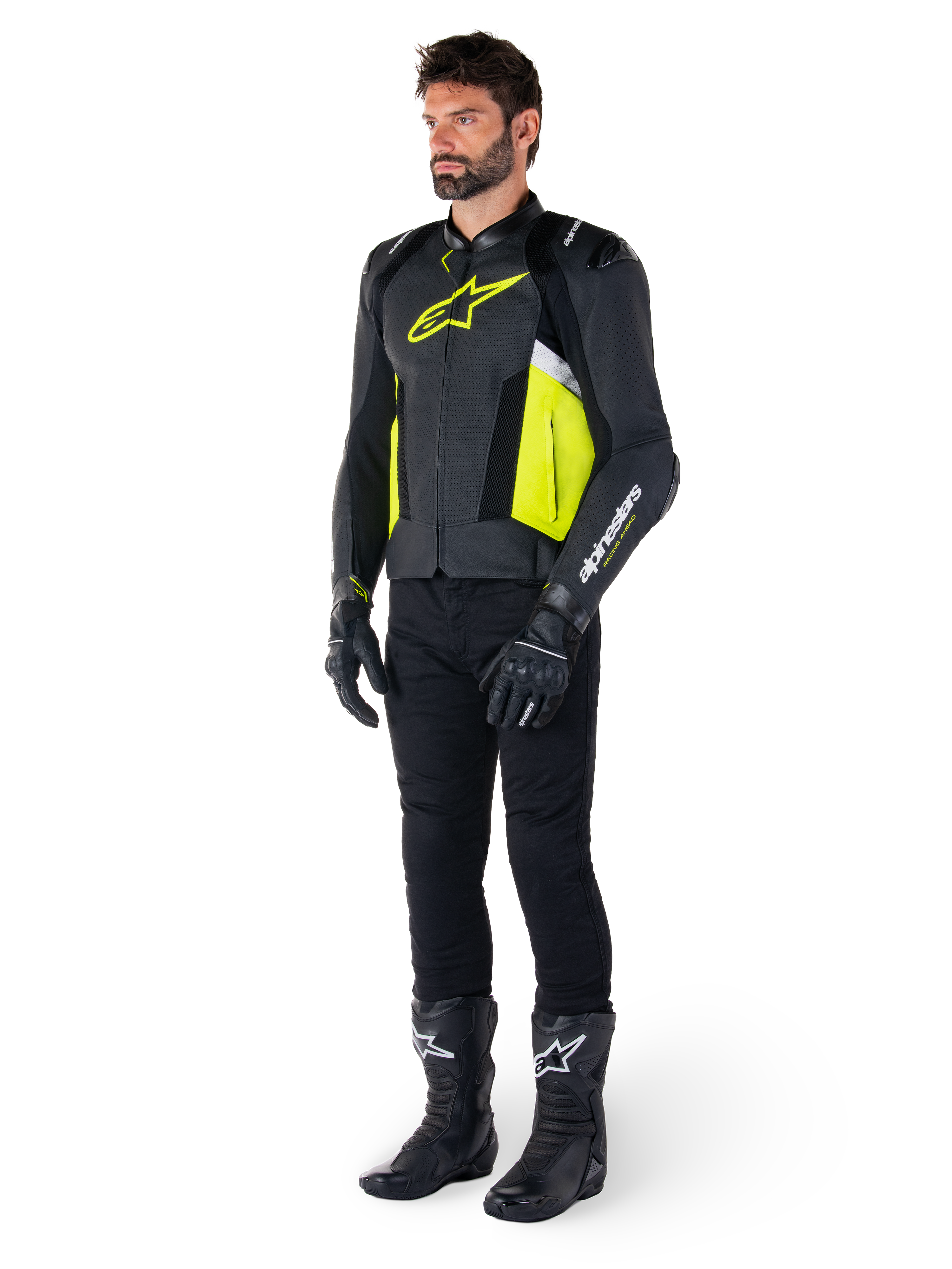Mandlig model iført Alpinestars Missile V3 Airflow læderjakken i sort, gul fluo og hvid, stylet med sorte kørehandsker, bukser og støvler, der fremviser det perforerede læderdesign og den racing-inspirerede æstetik.