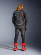 Alpinestars GP Force V2 læderjakke, sort og rød fluo, set bagfra, båret med matchende sorte læderbukser og stærkt røde racingstøvler, med røde accentlinjer og tydelig hvid Alpinestars-branding på ryggen, professionelt sportsmotorcykeloutfit