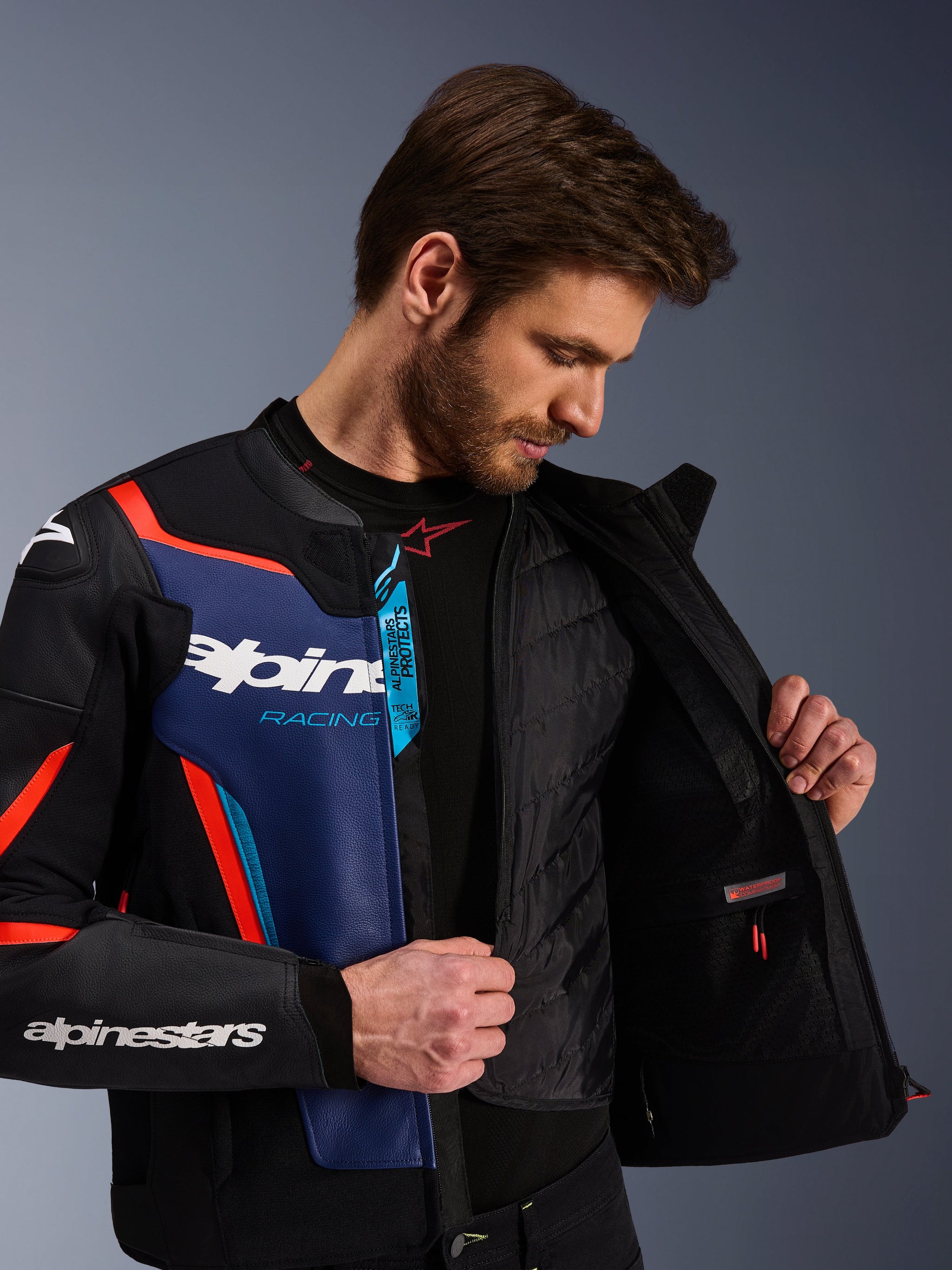 Alpinestars GP Force V2 læderjakke i sort, blå og rød fluo, nærbillede der viser den indvendige aftagelige termovest og vandtætte lomme, premium okselæder med Tech-Air Ready branding, sportsoptimeret motorcykelbeklædning.