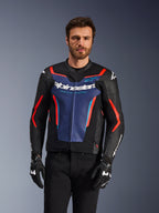 Alpinestars GP Force V2 læderjakke, sort, blå og rød fluo, båret af en mandlig model med sorte handsker og bukser, med et blåt brystpanel med 'Alpinestars Racing Ahead'-tekst, røde detaljer og eksterne skulderskjolde, beskyttelsesudstyr til sportsmotorcykel
