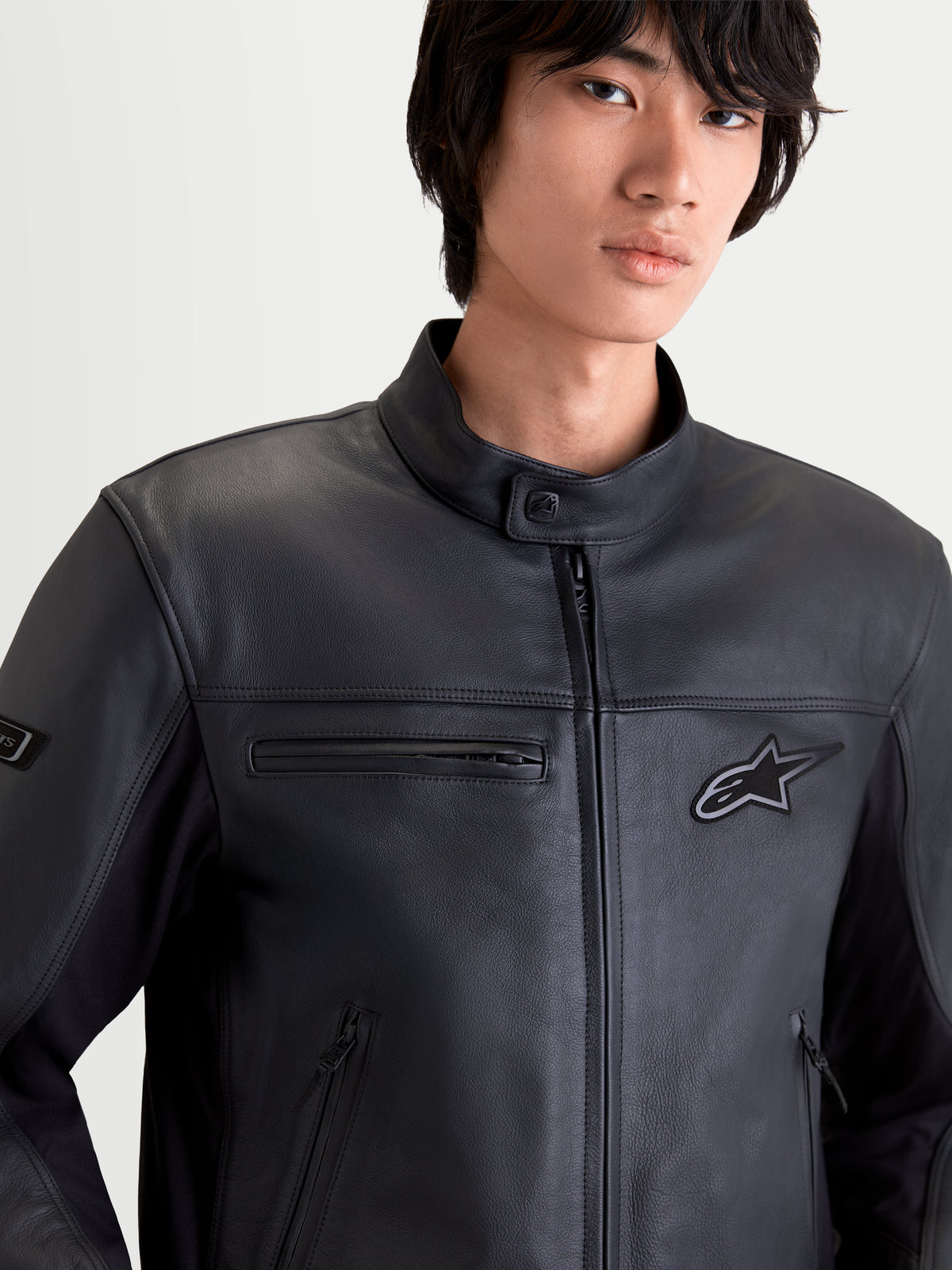 Alpinestars Maver-X Leather Jacket, men's urban contemporary motorcycle jacket in black, close-up front view on a model wearing premium bovine leather gear with zippered pockets and a biker collar