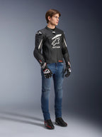 Alpinestars GP Plus R V4 Rideknit Leather Jacket, Black and White, motorcycle leather jacket worn by a model with blue jeans and black gloves, featuring a prominent white Astars logo on the chest, perforated panels, and white accents on the shoulders.