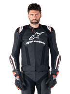 Alpinestars Missile V3 Ignition læderjakke, sort med hvide og røde detaljer, båret af en mandlig model med matchende racinghandsker og -bukser, MotoGP-afledt sportsmotorcykeljakke med markant branding