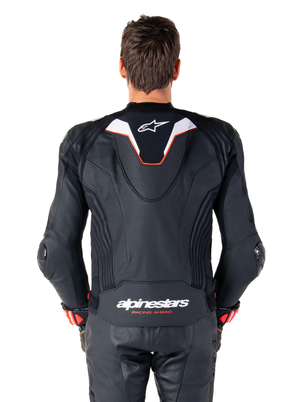 Alpinestars Missile V3 Ignition læderjakke set bagfra, sort læder med hvide og røde detaljer, slank sport aero-hump med hvidt logo, 'alpinestars RACING AHEAD' branding på den nedre ryg, kombineret med matchende sorte læderracerbukser og handsker.