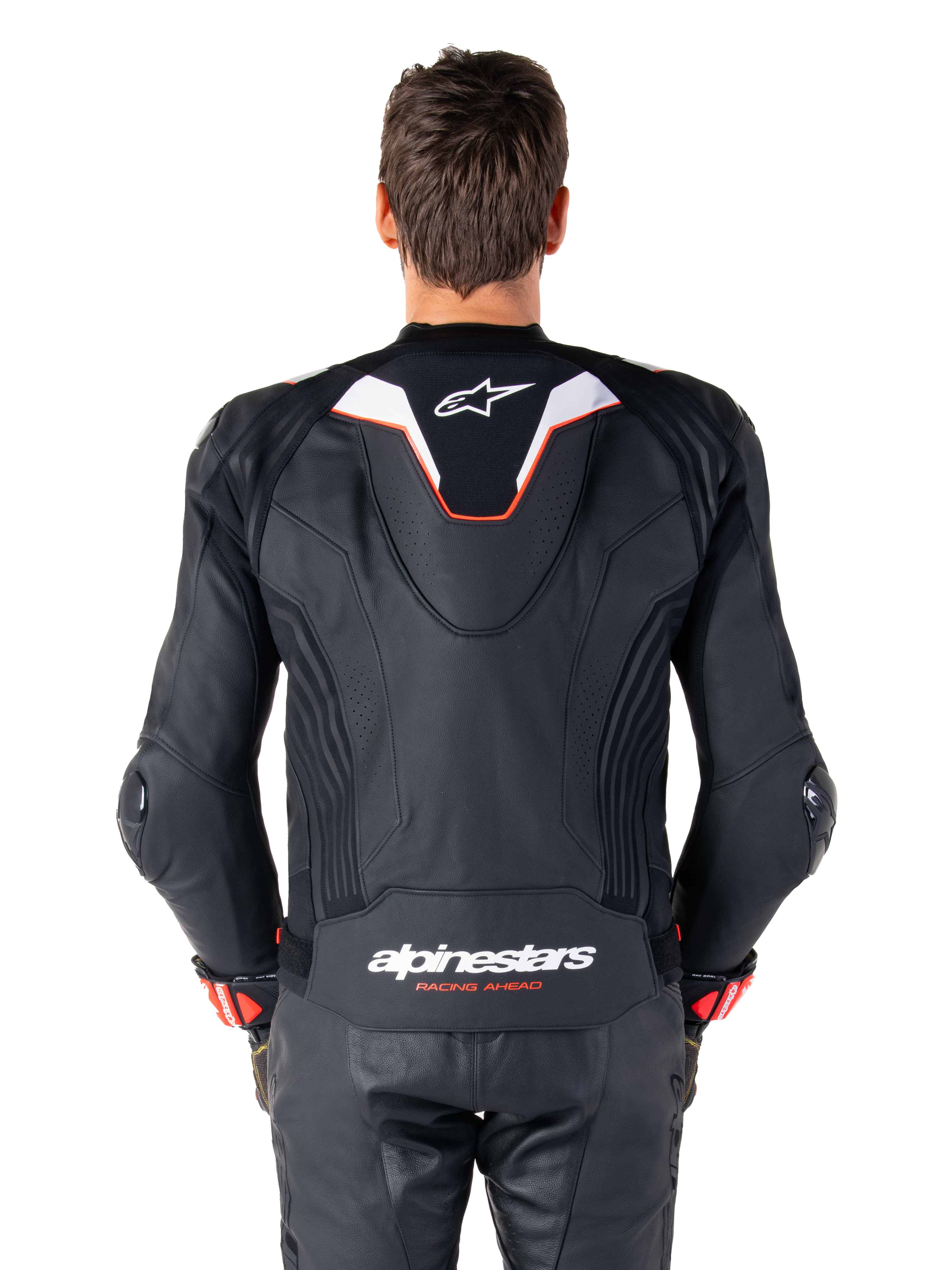 Alpinestars Missile V3 Ignition læderjakke set bagfra, sort læder med hvide og røde detaljer, slank sport aero-hump med hvidt logo, 'alpinestars RACING AHEAD' branding på den nedre ryg, kombineret med matchende sorte læderracerbukser og handsker.