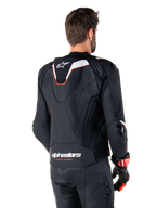 Alpinestars Missile V3 Ignition læderjakke, set bagfra, sort med hvide og røde detaljer, med en slank sport Aero-hump og Alpinestars-branding, båret med matchende læderbukser og racinghandsker