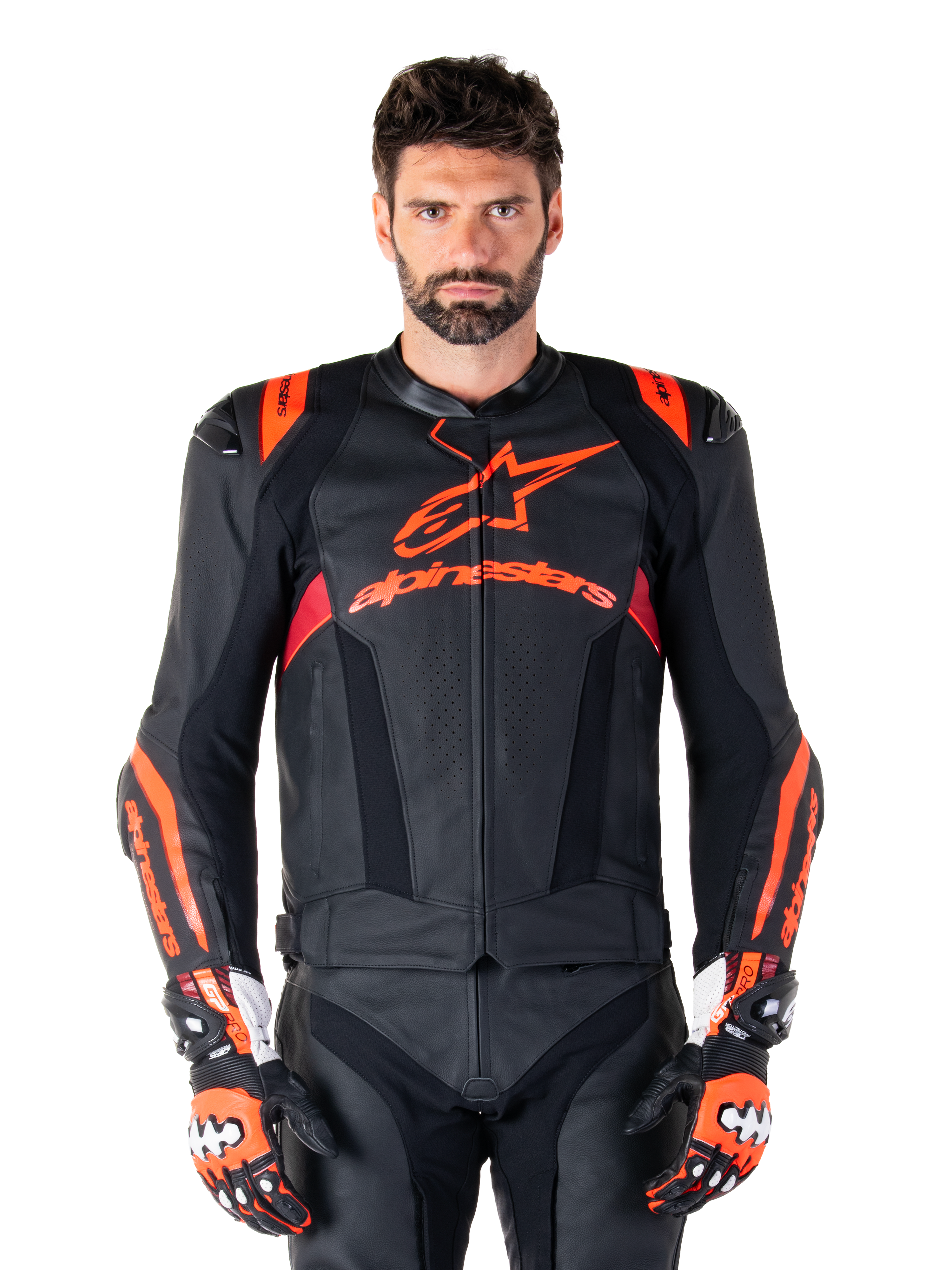 Alpinestars Missile V3 Ignition læderjakke, motorcykelracingjakke, sort og rød fluo, bæres med matchende racinghandsker og læderbukser, med perforeret ventilation og markant Alpinestars-branding, professionelt racingudstyr