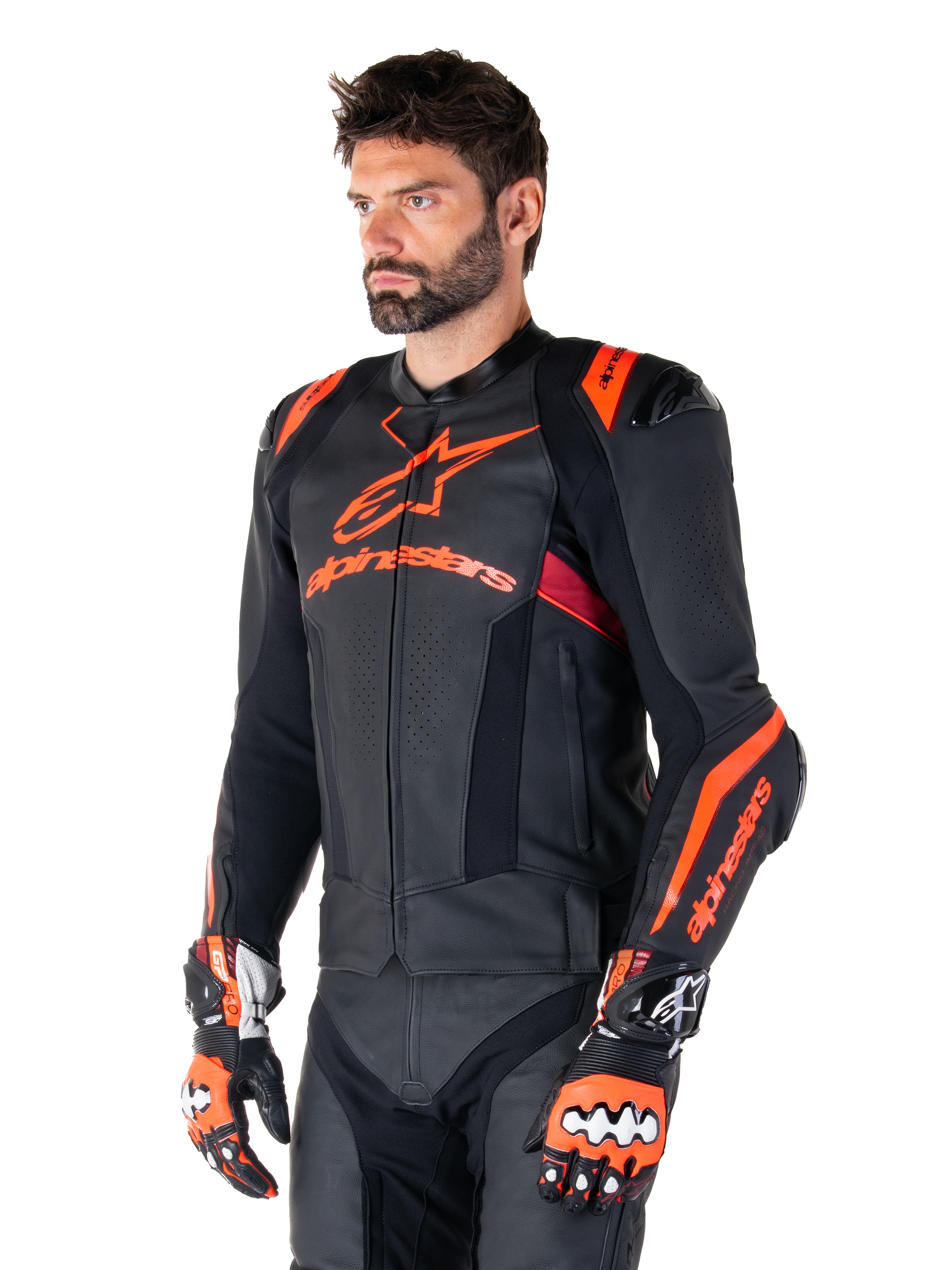 Alpinestars Missile V3 Ignition læderjakke, sort med Red Fluo og mørkerøde detaljer, båret af en mandlig model med matchende racinghandsker og læderbukser, markant Alpinestars-branding, perforerede læderpaneler og eksterne skulderbeskyttere, professionelt motorcykel-racingudstyr