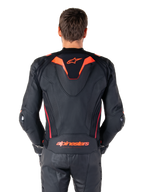 Alpinestars Missile V3 Ignition læderjakke, set bagfra, sort med rød fluo og mørkerøde detaljer, med sport aero-hump, Alpinestars-branding på ryggen, båret med matchende sorte læder motorcykelbukser, højtydende motorcykelracerudstyr