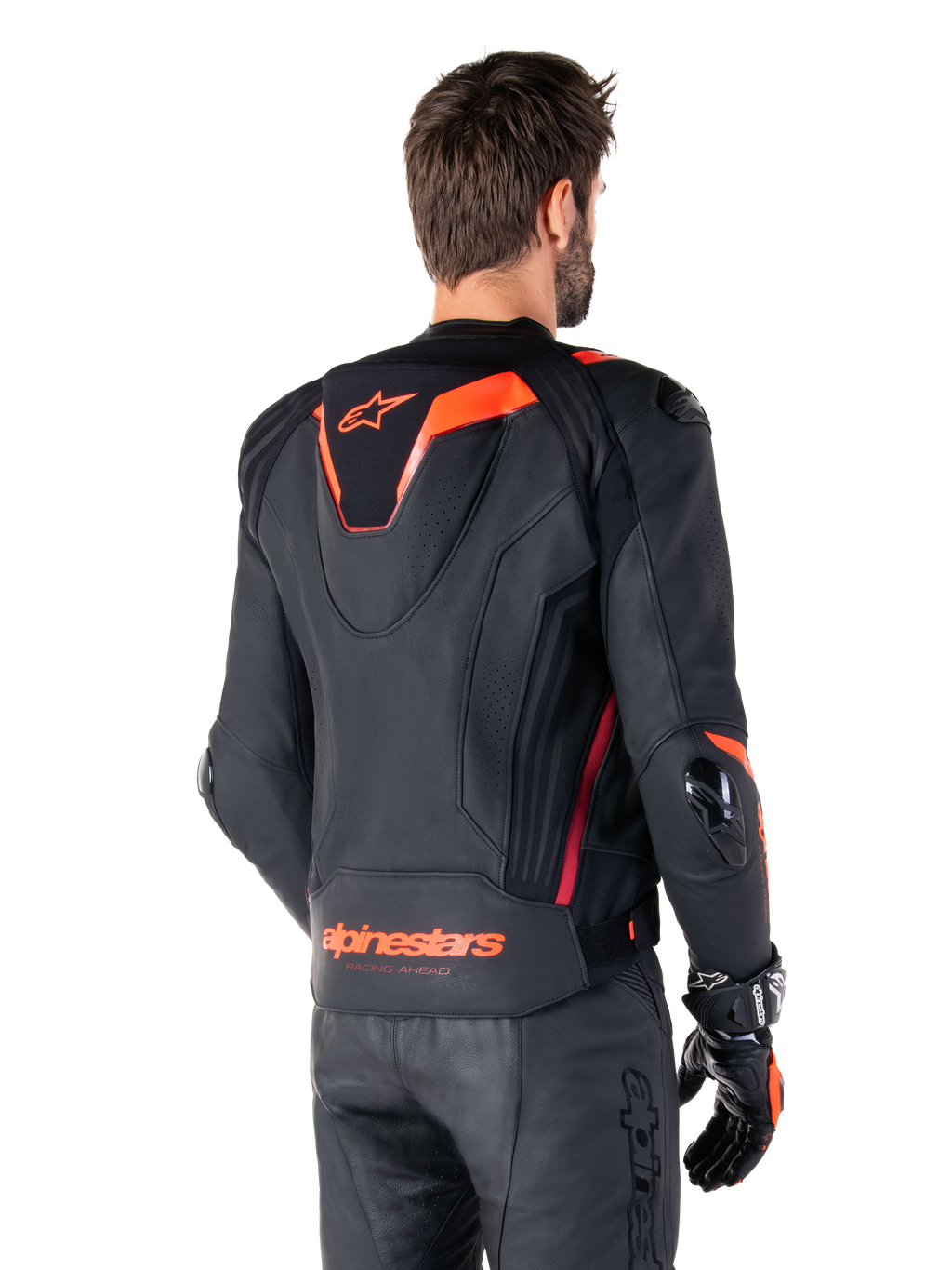 Alpinestars Missile V3 Ignition læderjakke, racing sport jakke til mænd, sort med Red Fluo-detaljer, set bagfra med den slanke aerodynamiske sport-hump og Alpinestars-branding på den nederste del af ryggen, båret med sorte læderbukser og racing-handsker, strømlinet professionelt motorsport-design