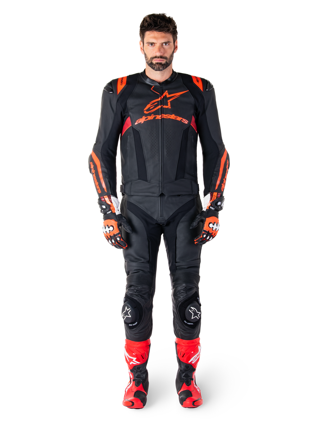 Mandlig model iført Alpinestars Missile V3 Ignition læderjakke i sort, rød fluo og mørkerød, komplet motorcykel-racerudstyr inklusive matchende læderbukser, racerhandsker og støvler, med tydeligt Alpinestars-logo på brystet, frontvendt positur, professionelt sportskøreudstyr