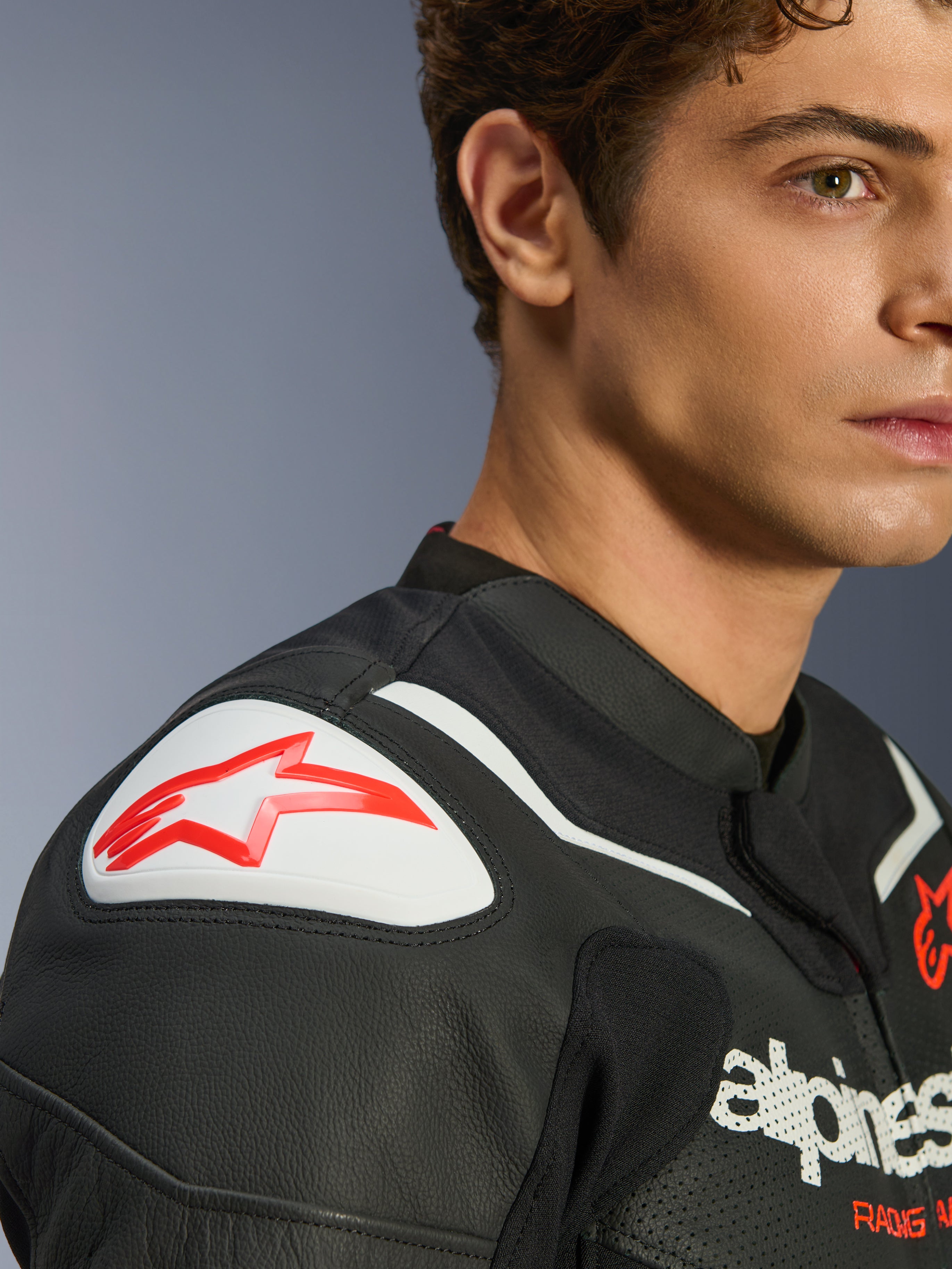 Alpinestars GP Force V2 Air læderjakke, sort og hvid, nærbillede af model iført jakken, hvid GP Lite Evo DFS skulder-slider med rødt logo, perforeret læderdetalje.