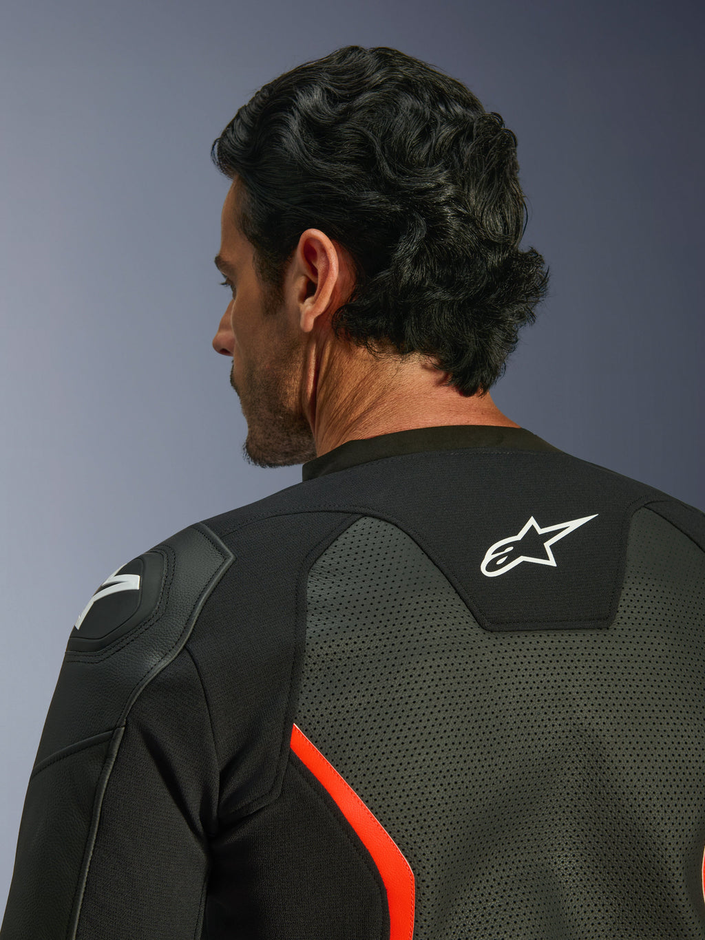 Alpinestars GP Force V2 Air læderjakke, sort og rød fluo, nærbillede af øvre ryg og skulder, omfattende læderperforeringer for luftgennemstrømning, hvidt logo på ryggen, GP Lite Evo-skulderbeskyttelse
