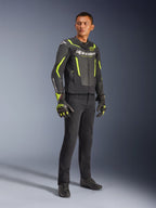 Mandlig model iført Alpinestars GP Force V2 Air læderjakke i sort og gul fluo, sorte kørebukser, matchende handsker og sorte sko, fuld figur studiefoto af sportsmotorcykeludstyr med perforeret læder og tydelig branding