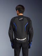 Alpinestars GP Force V2 Airflow læderjakke, Sort Metallic Blå, set bagfra, med et stort perforeret rygpanel til ventilation, blå detaljer og hvid Alpinestars-branding, båret med matchende blå handsker og sorte bukser til sportskørsel.