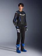 Mandlig kører iført GP Force V2 Airflow-læderjakke i Black Metallic Blue, kombineret med matchende racerhandsker og blå støvler, med perforeret læder og tydelig Alpinestars-branding, professionelt motorcykeludstyr til vejbrug.