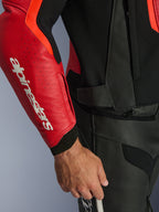 Alpinestars GP Force V2 Air læderjakke, rød og rød fluo, tæt på perforeret læderærme med tydeligt hvidt Alpinestars-logo, sorte teksturerede paneler og lynlås til fastgørelse i taljen, førsteklasses sportsbeskyttelse til kørsel