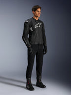 Alpinestars Dusk Airflow læderjakke, sort og hvid, vist med sorte motorcykelbukser, handsker og støvler, med perforerede læderpaneler og hvidt logo, sportslig road racing-stil.