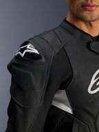 Alpinestars Dusk Airflow læderjakke, sort og hvid, nærbillede af skulder og bryst, perforeret læder til ventilation, DFS-skulderbeskyttelse med hvidt Alpinestars-logo, sportsligt design