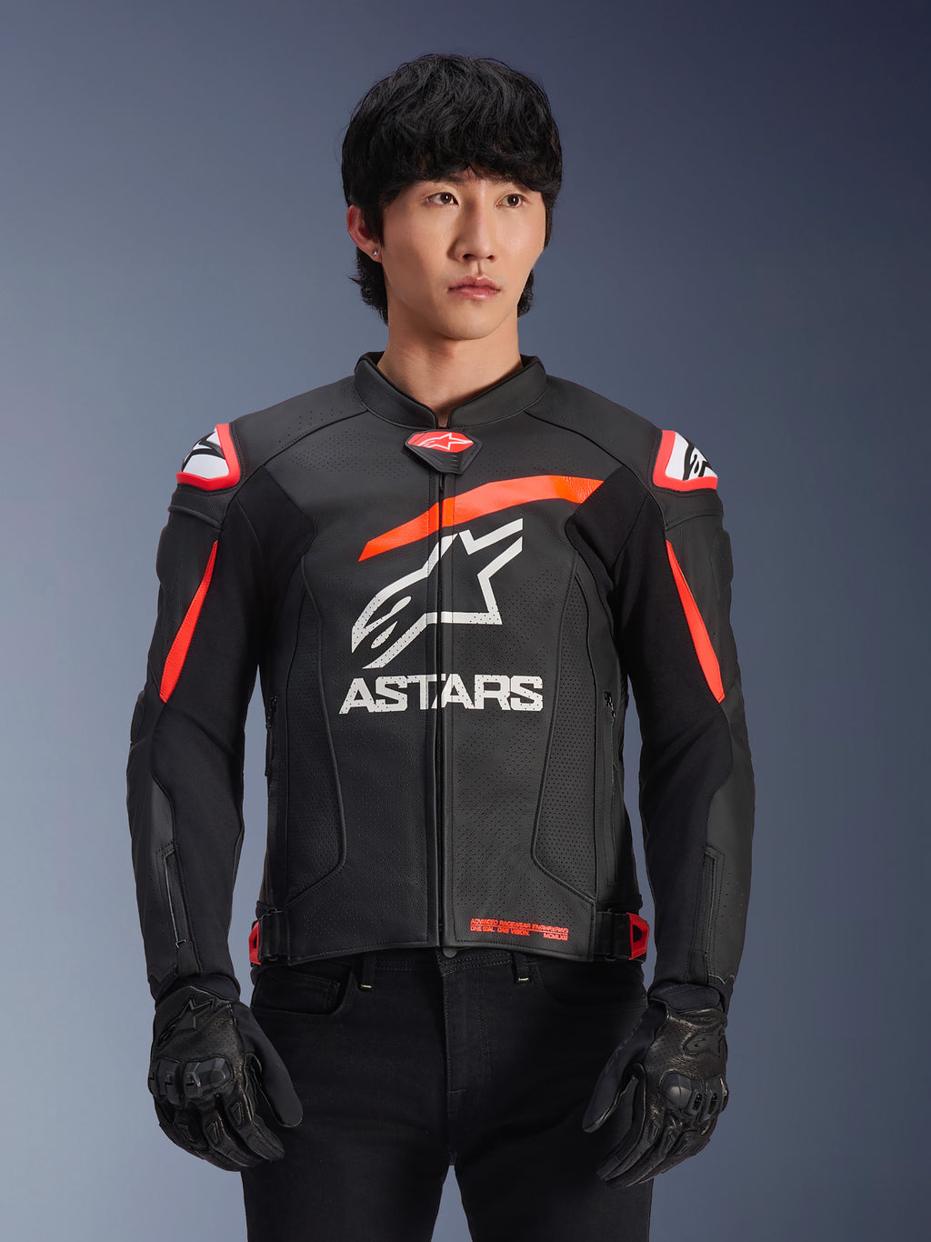 Alpinestars GP Plus R V4 Airflow læderjakke i sort med rød fluo og hvide detaljer, båret af en model, med perforeret læderkonstruktion, et stort hvidt ASTARS-logo på brystet og integreret skulderbeskyttelse til motorcykelracing