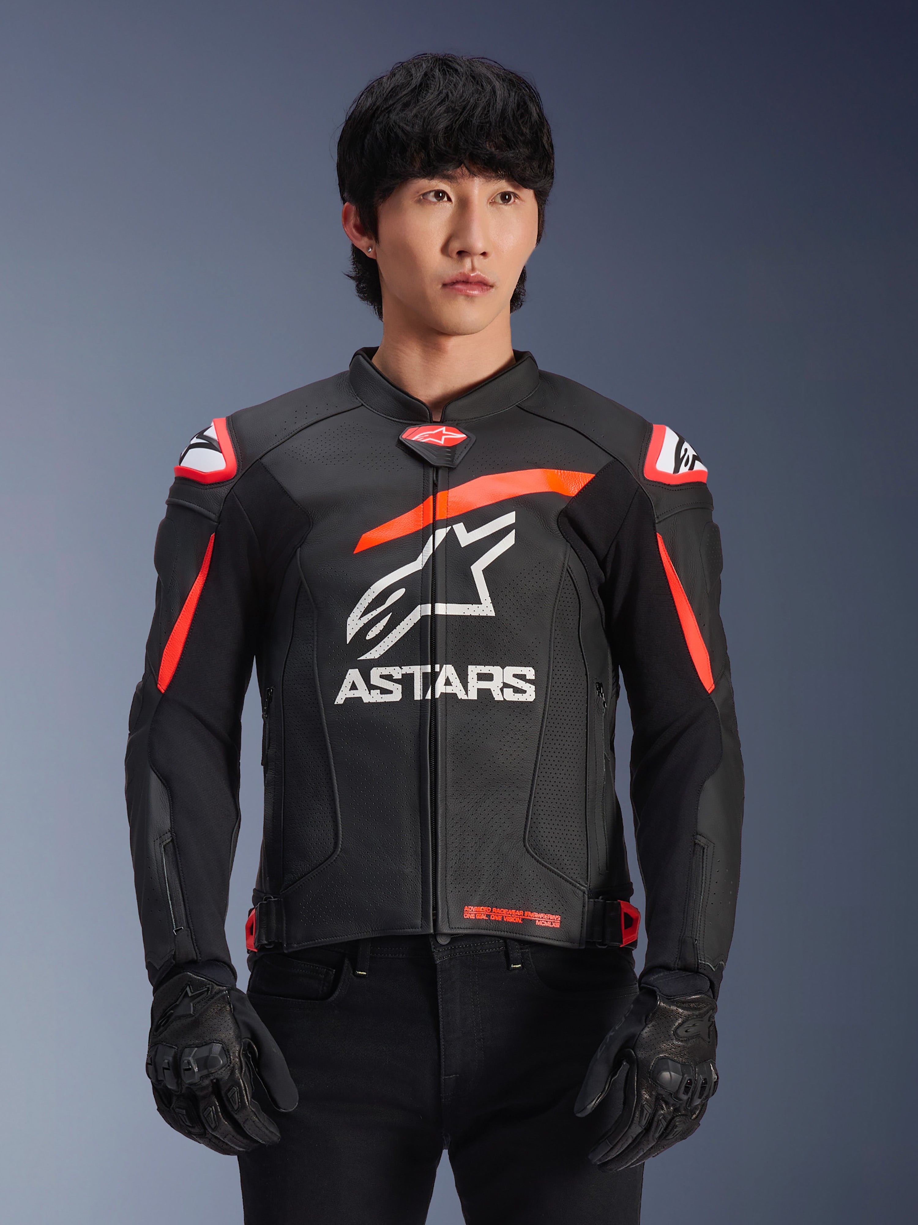 Alpinestars GP Plus R V4 Airflow læderjakke i sort med rød fluo og hvide detaljer, båret af en model, med perforeret læderkonstruktion, et stort hvidt ASTARS-logo på brystet og integreret skulderbeskyttelse til motorcykelracing