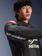 Alpinestars GP Plus R V4 Airflow læderjakke, motorcykeljakke, sort, rød fluo og hvid, båret af model, nærbillede af armen med hvidt Alpinestars-logo, røde og hvide skulderdetaljer, perforeret læder til ventilation, professionelt racerinspireret design