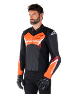 Alpinestars Faster V3 læderjakke, sort og fluorød, premium sportsjakke med hvide og røde detaljer, Alpinestars-branding på bryst og ærmer, båret med sorte motorcykelhandsker og bukser.