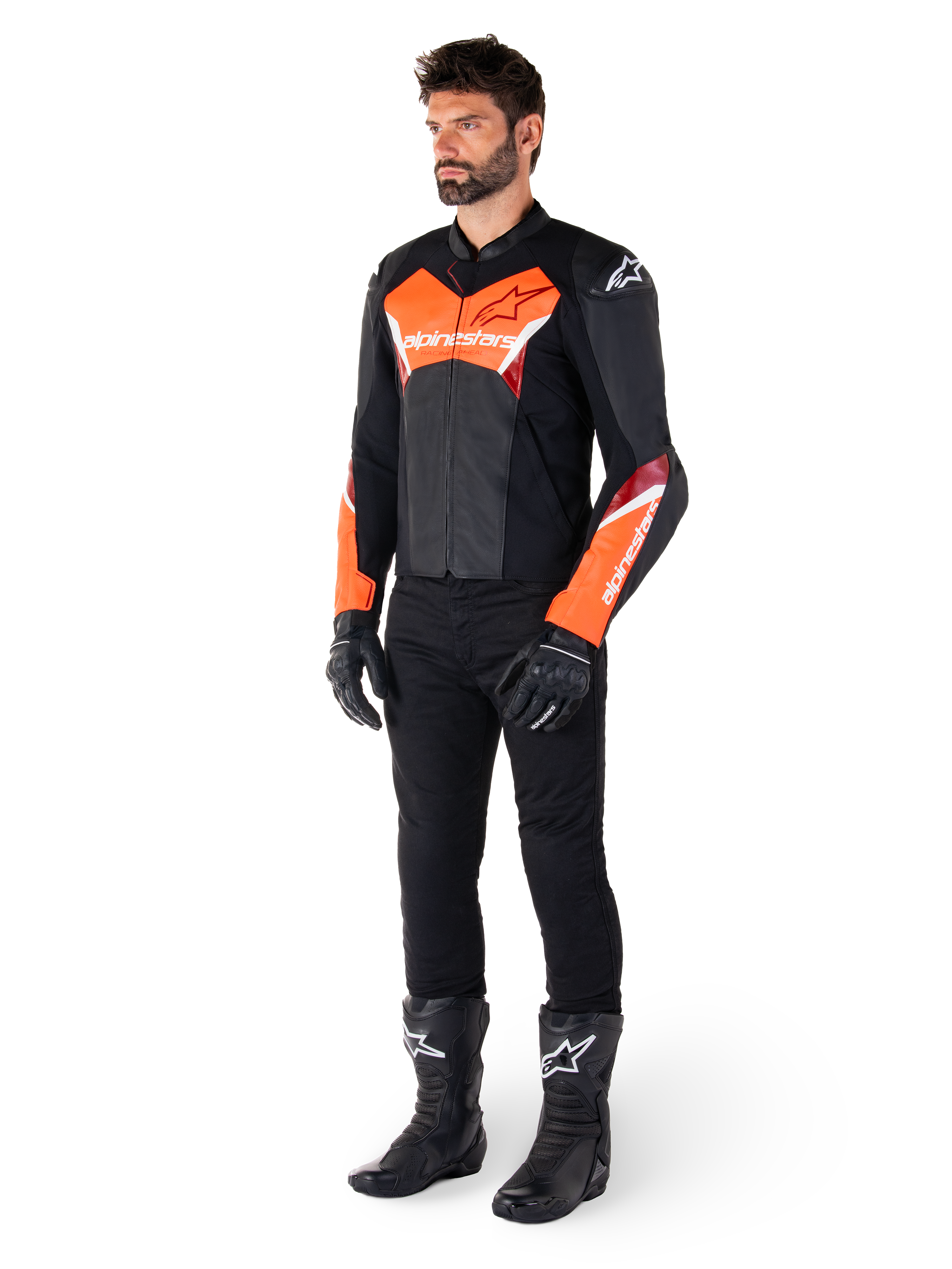 Mandlig motorcyklist iført Alpinestars Faster V3 læderjakke i sort og fluorescerende rød, kombineret med sorte kørebukser, handsker og støvler, race-inspireret silhuet med markante røde detaljer på bryst og ærmer, hvid Alpinestars branding, førsteklasses læderkonstruktion