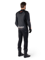 Alpinestars Faster V3 læderjakke, sportsmotorcykeljakke, sort og rød fluo, set bagfra båret med sorte bukser og sorte støvler, med 'alpinestars RACING AHEAD'-tekst nederst på ryggen og et lille rødt stjernelogo, strømlinet læderkonstruktion med sportspasform