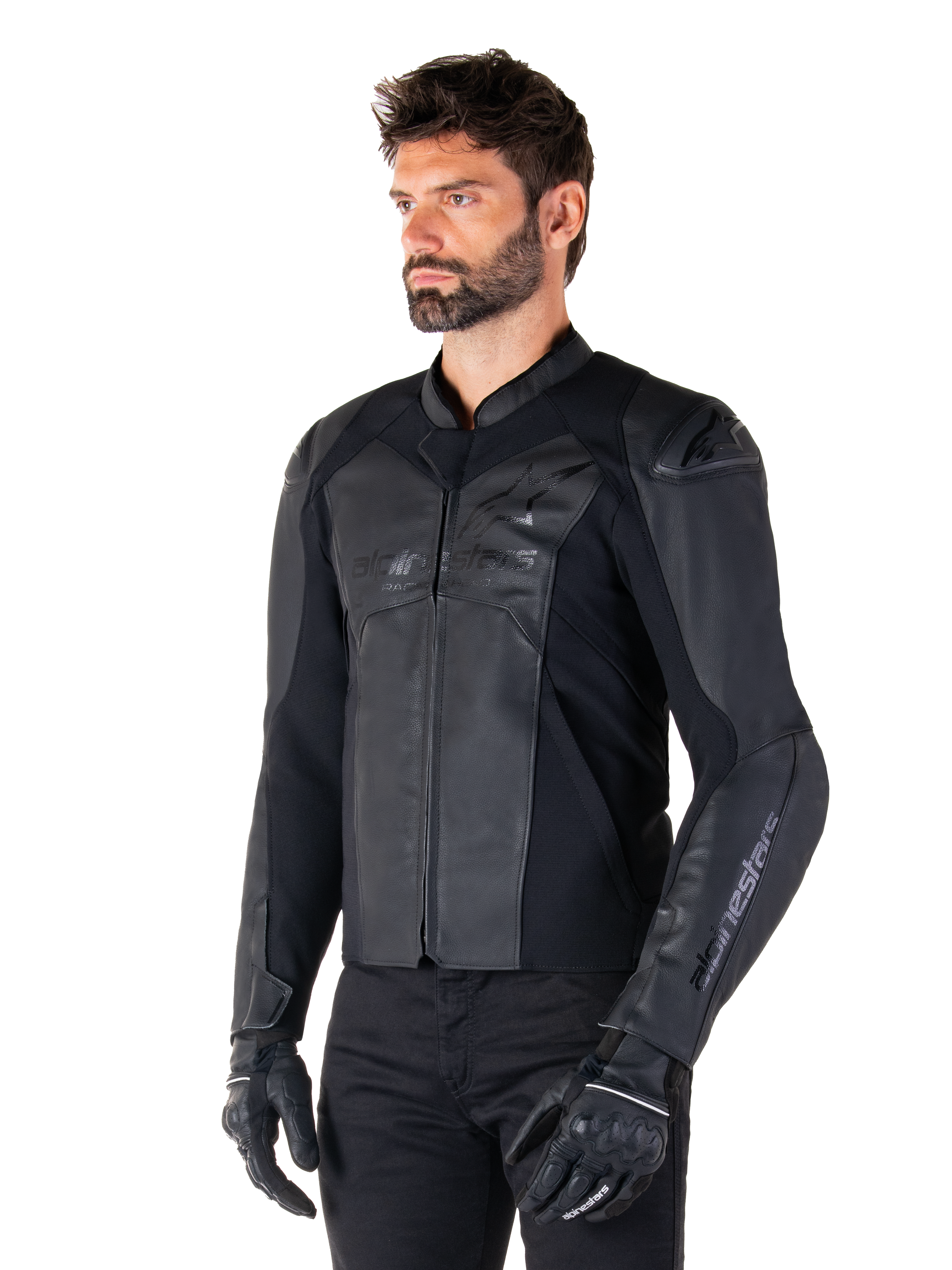 Alpinestars Faster V3 læderjakke, sportskørejakke, sort, båret af en mandlig model med sorte bukser og handsker, førsteklasses læderkonstruktion med strækpaneler og DFS GP Lite-skulderbeskyttere, slank og moderne sportssilhuet