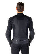 Set bagfra af en mand iført Alpinestars Faster V3 læderjakke i Black Black, med premium læderpaneler og fleksible strækindsatser, diskret 'alpinestars' og 'RACING AHEAD' branding på den nederste del af ryggen, atletisk sportspasform til motorcykelkørsel.