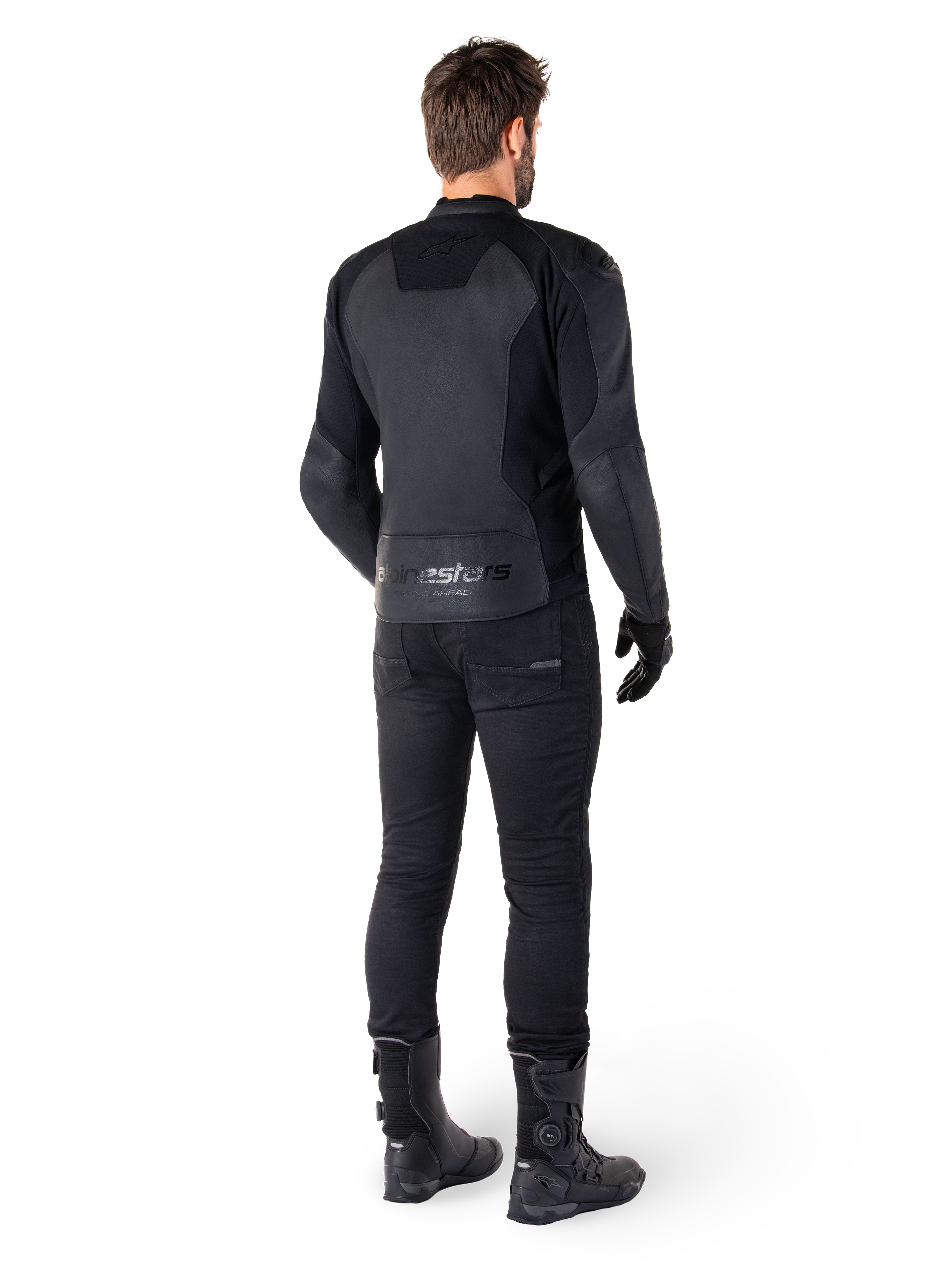 Alpinestars Faster V3 læderjakke, sort, set bagfra på en motorcyklist, med premium læderpaneler og præget Alpinestars-branding, kombineret med sorte kørebukser og støvler for et komplet sportsmotorcykel-look.
