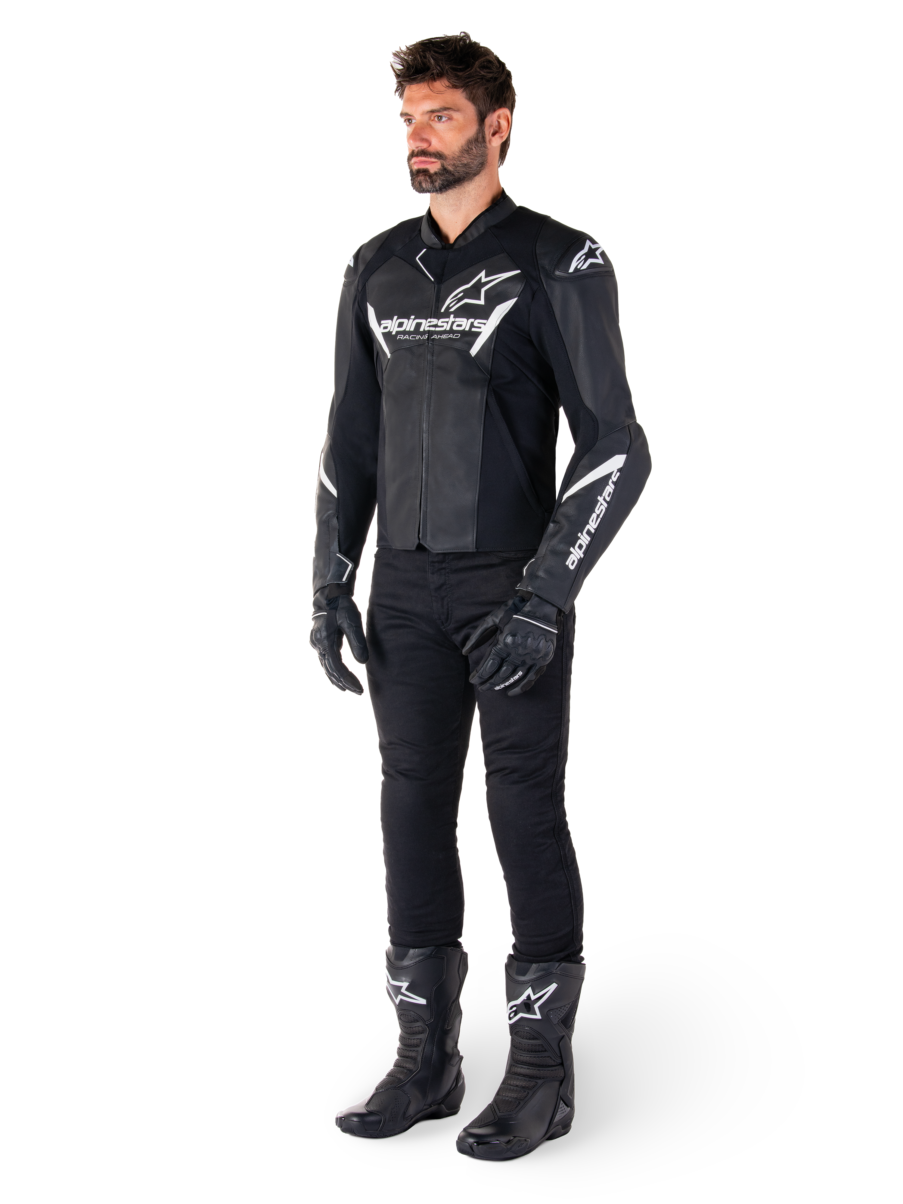 Male model wearing Alpinestars Faster V3 Leather Jacket, Sport Riding Jacket, Black and White, paired with black motorcycle pants, gloves, and boots, featuring white branding and logos, sport-fit silhouette for road racing