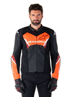 Alpinestars Faster V3 Airflow læderjakke, motorcykeljakke til racing, sort og rød fluo, perforeret læderkonstruktion med hvide og røde detaljer, båret med sorte handsker, performance-udstyr til gadekørsel