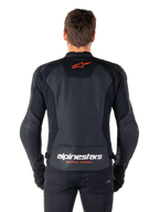 Alpinestars Faster V3 Airflow læderjakke, sort, set bagfra med perforerede læderpaneler for ventilation, rødt Alpinestars-stjernelogo og hvid branding på den nedre ryg, båret med sorte bukser og handsker.