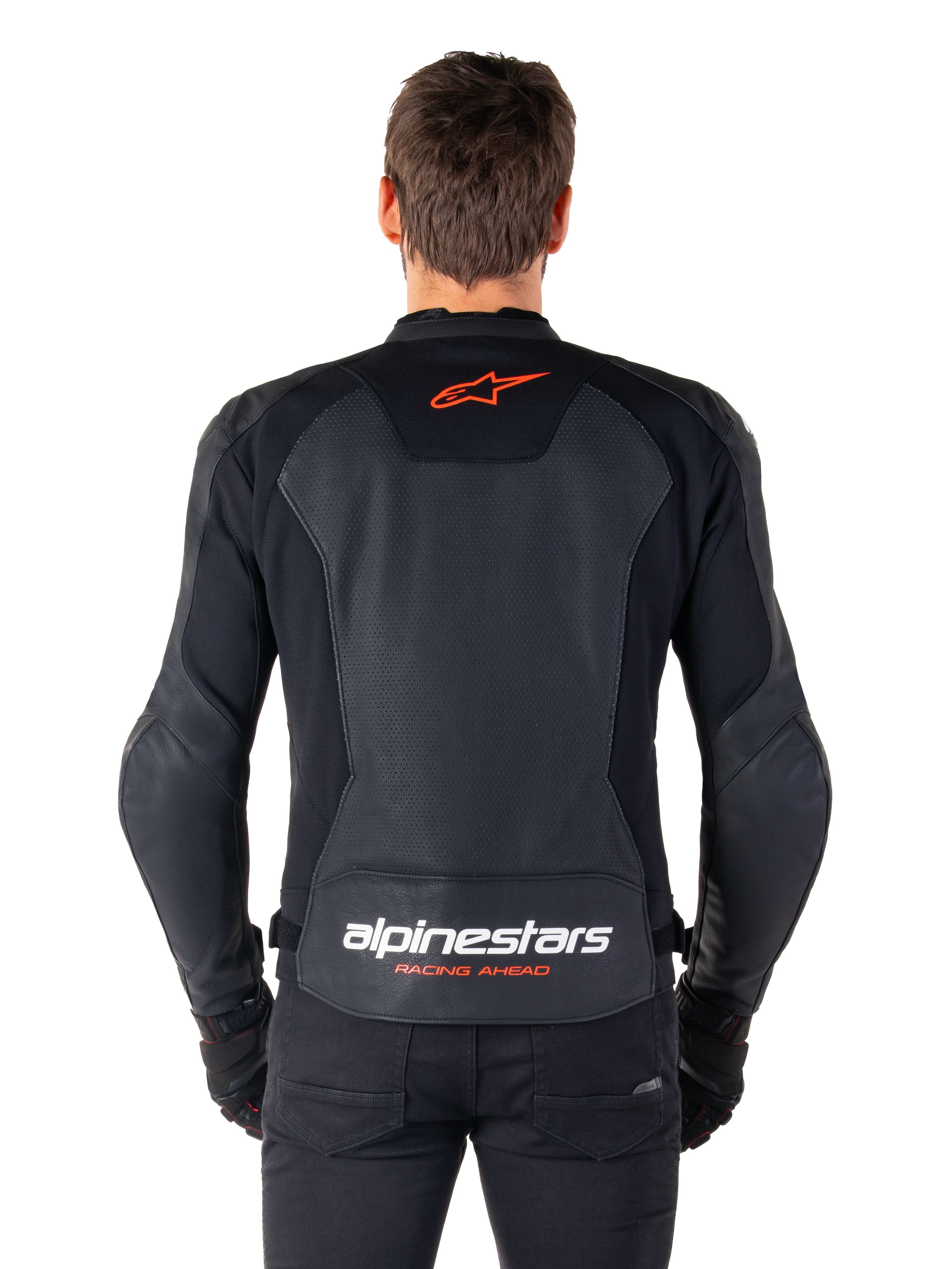 Alpinestars Faster V3 Airflow læderjakke, sort, set bagfra med perforerede læderpaneler for ventilation, rødt Alpinestars-stjernelogo og hvid branding på den nedre ryg, båret med sorte bukser og handsker.