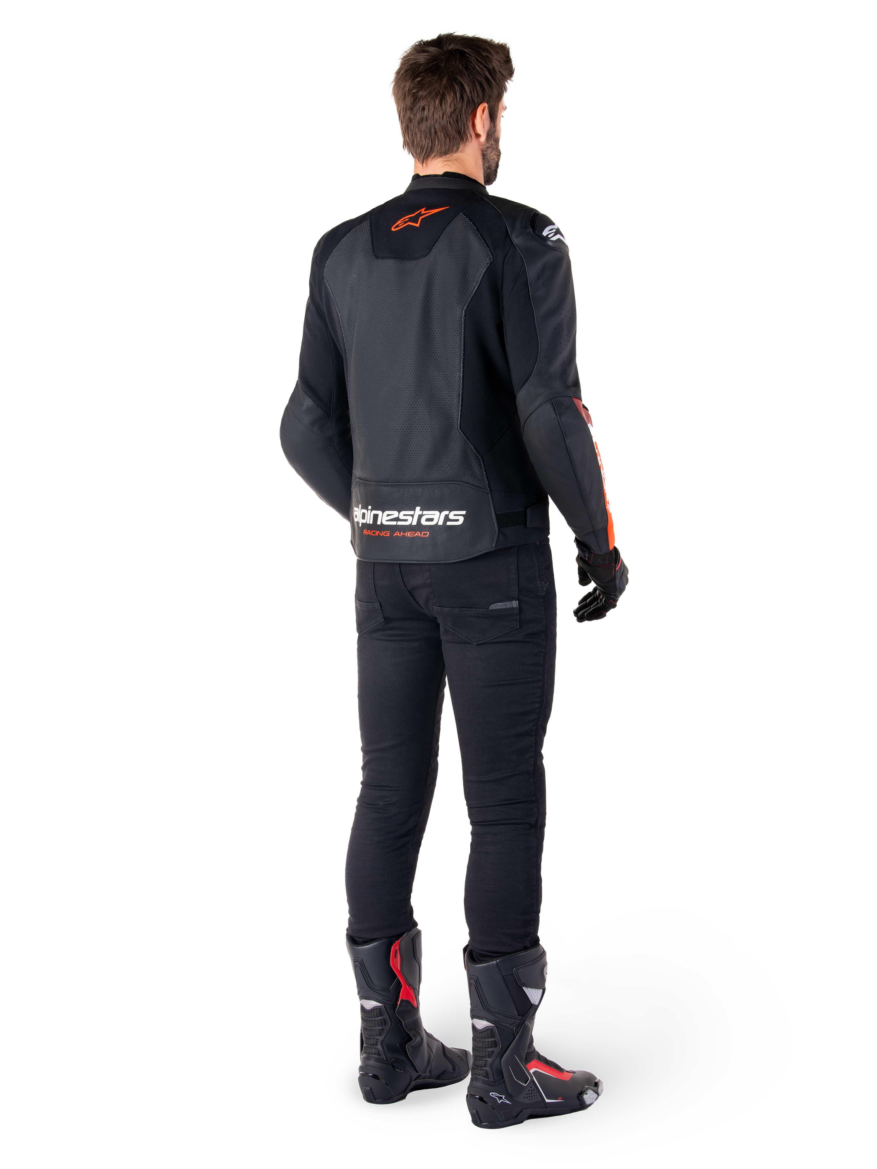 Alpinestars Faster V3 Airflow læderjakke, sort og rød fluo, set bagfra på en kører, med perforerede læderpaneler og tydelig branding, båret med sorte bukser og motorcykelstøvler, sportsbeklædning til motorcykel