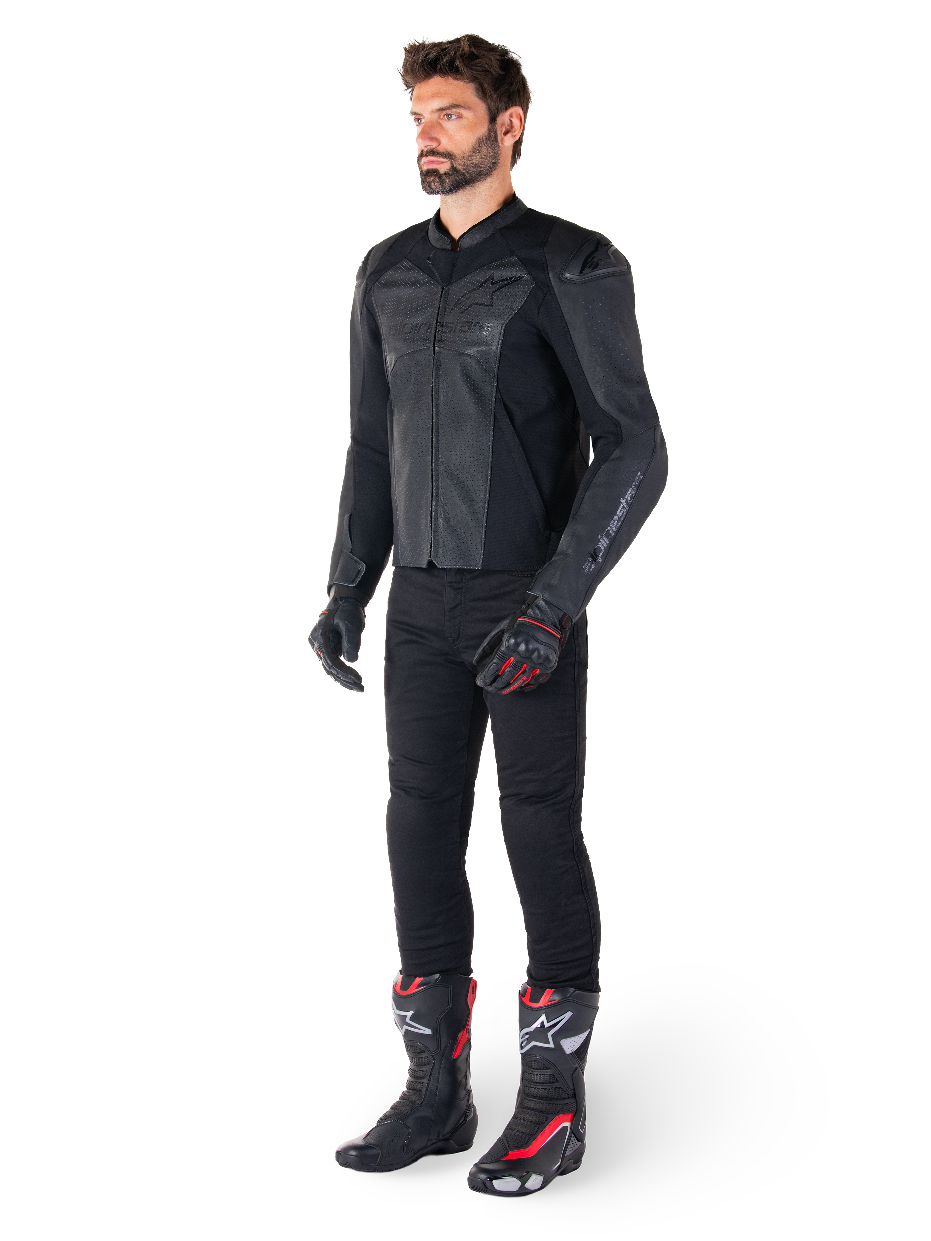 Mand iført Alpinestars Faster V3 Airflow læderjakke i Black Black, kombineret med sorte bukser, sorte og røde motorcykelhandsker og sorte racestøvler med røde og hvide detaljer, komplet sportsudstyr til kørsel