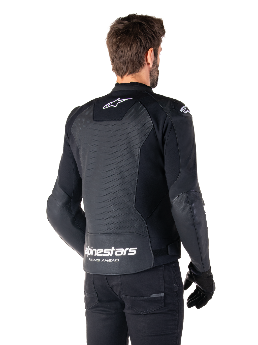 Alpinestars Faster V3 Airflow læderjakke, sort og hvid, set bagfra på en model, med perforeret læderryg for ventilation, hvide Astars-logoer på den øverste del af ryggen og nederst på lænden med 'Racing Ahead'-tekst, sporty design med strækpaneler til motorcykelbrug.
