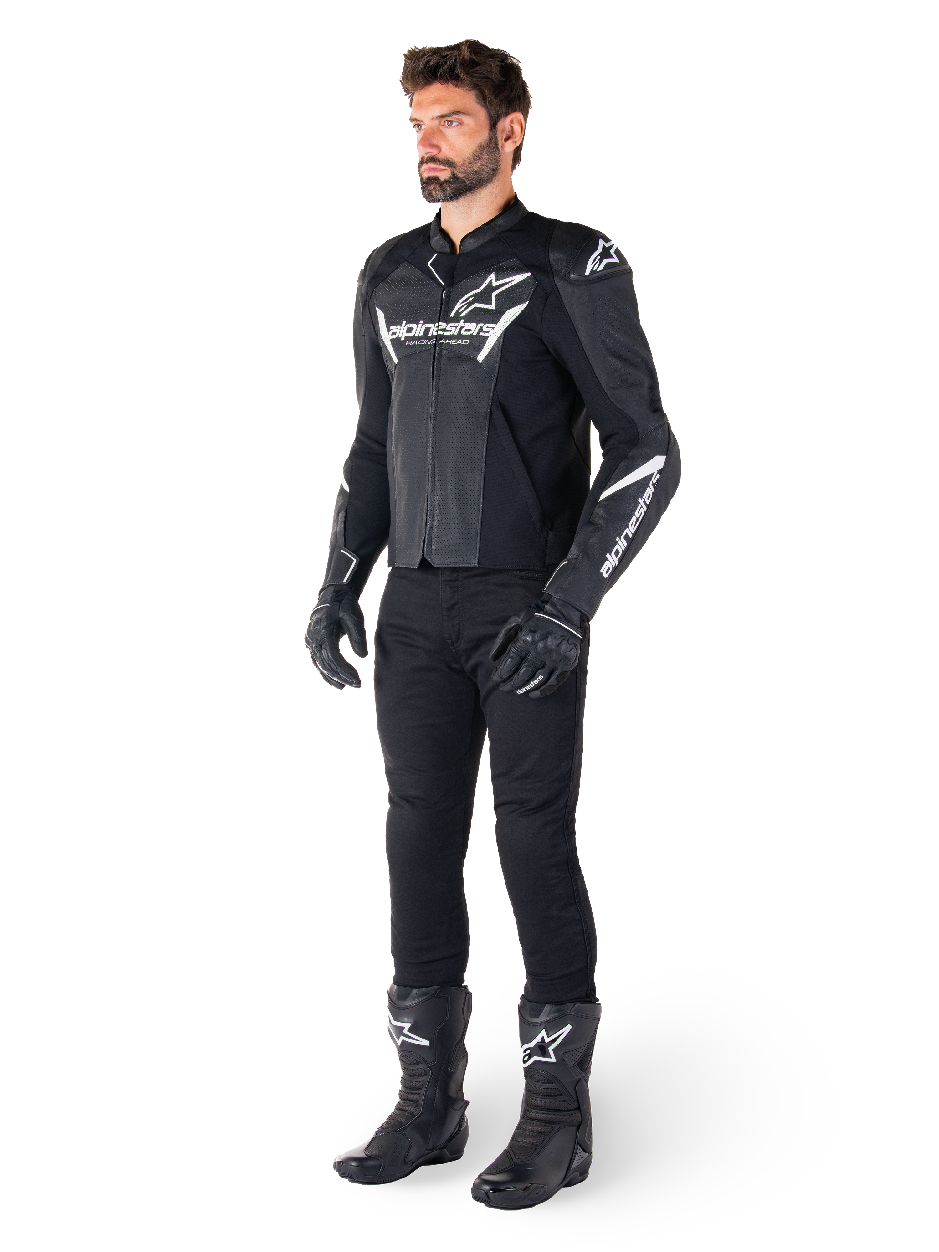 Model iført Alpinestars Faster V3 Airflow læderjakke, sort og hvid, med perforeret læder og hvide Alpinestars-logoer, kombineret med sorte kørebukser, handsker og støvler, sportsorienteret motorcykeludstyr