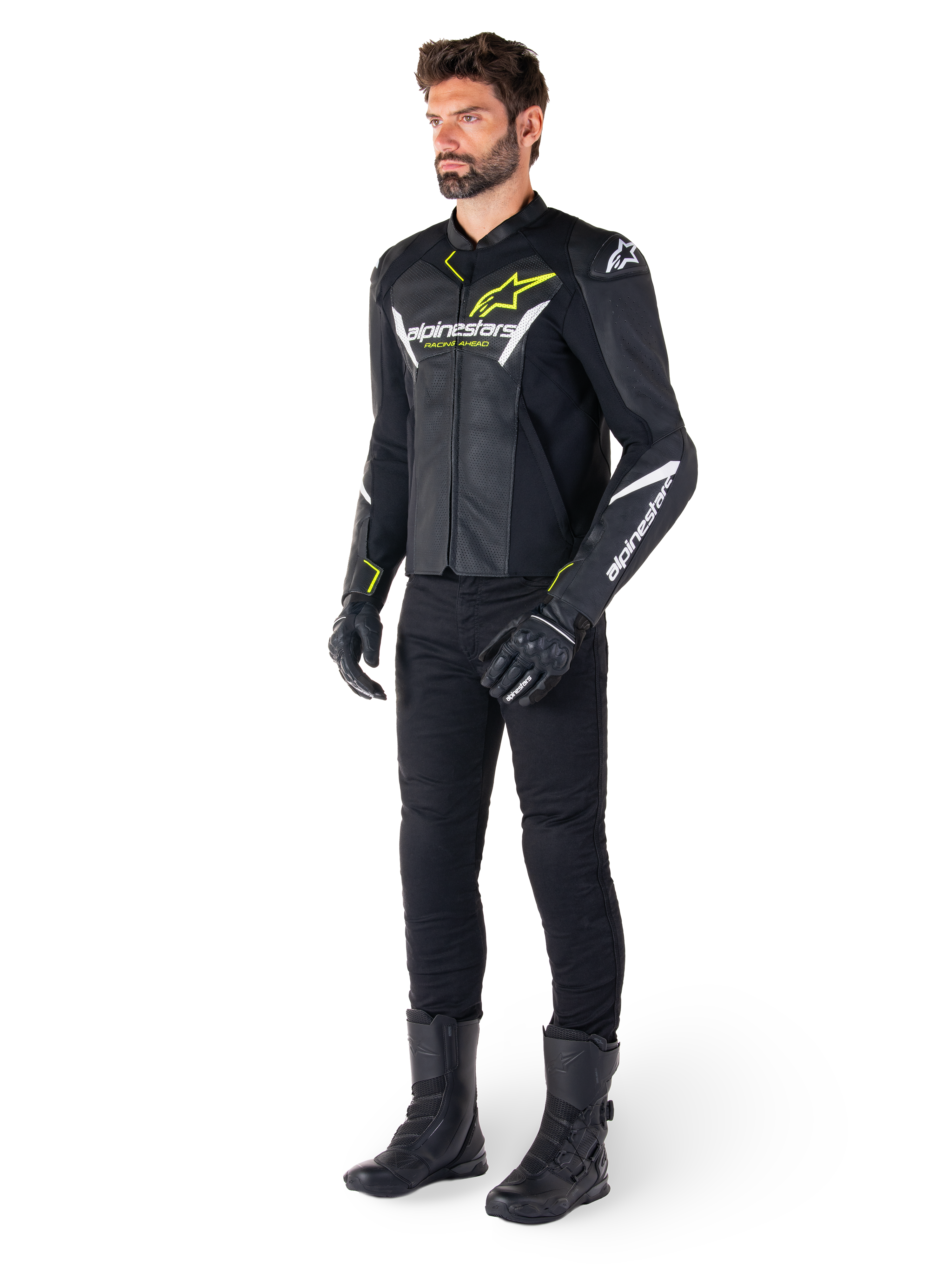 Mandlig rytter iført Alpinestars Faster V3 Airflow læderjakke i sort, hvid og gul fluo, kombineret med sorte motorcykelbukser og støvler, med perforerede læderpaneler, hvide logodetaljer og neongule accenter, professionelt sportsudstyr til kørsel