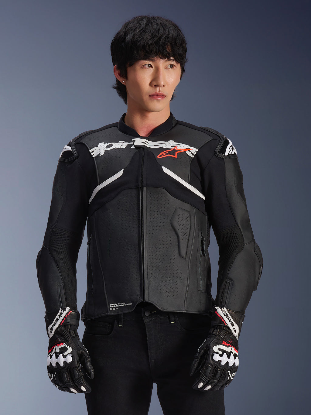 Alpinestars Atem V5 læderjakke, motorcykel-racingjakke, sort med hvide og røde detaljer, premium læderkonstruktion med beskyttelse, båret med matchende racinghandsker