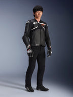 Alpinestars Atem V5 læderjakke, motorcykel racerjakke, sort og hvid, båret med sorte bukser og matchende handsker, med hvid Alpinestars-branding over brystet og beskyttende skulderbeskyttelse.