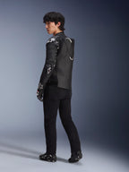 Mandlig model iført Alpinestars Atem V5-læderjakken i sort og hvid, trekvart visning bagfra, der viser den aerodynamiske hastighedspukkel og DFS RR-beskyttere, kombineret med sorte bukser, racerhandsker og støvler, professionelt motorcykel-racerudstyr