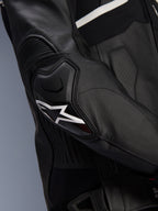 Alpinestars Atem V5 læderjakke, sort og hvid, tætbillede af DFS RR-albuebeskytteren med hvidt stjernelogo, med accordion-læder og perforerede teksturer til sportskørsel