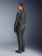 Alpinestars Stella Dusk læderjakke, motorcykeljakke til kvinder, sort og hvid, set bagfra med hvidt Alpinestars-logo på den nederste del af ryggen og skuldrene, båret med sorte kørebukser og støvler, sportsfokuseret ergonomisk pasform til landevejskørsel