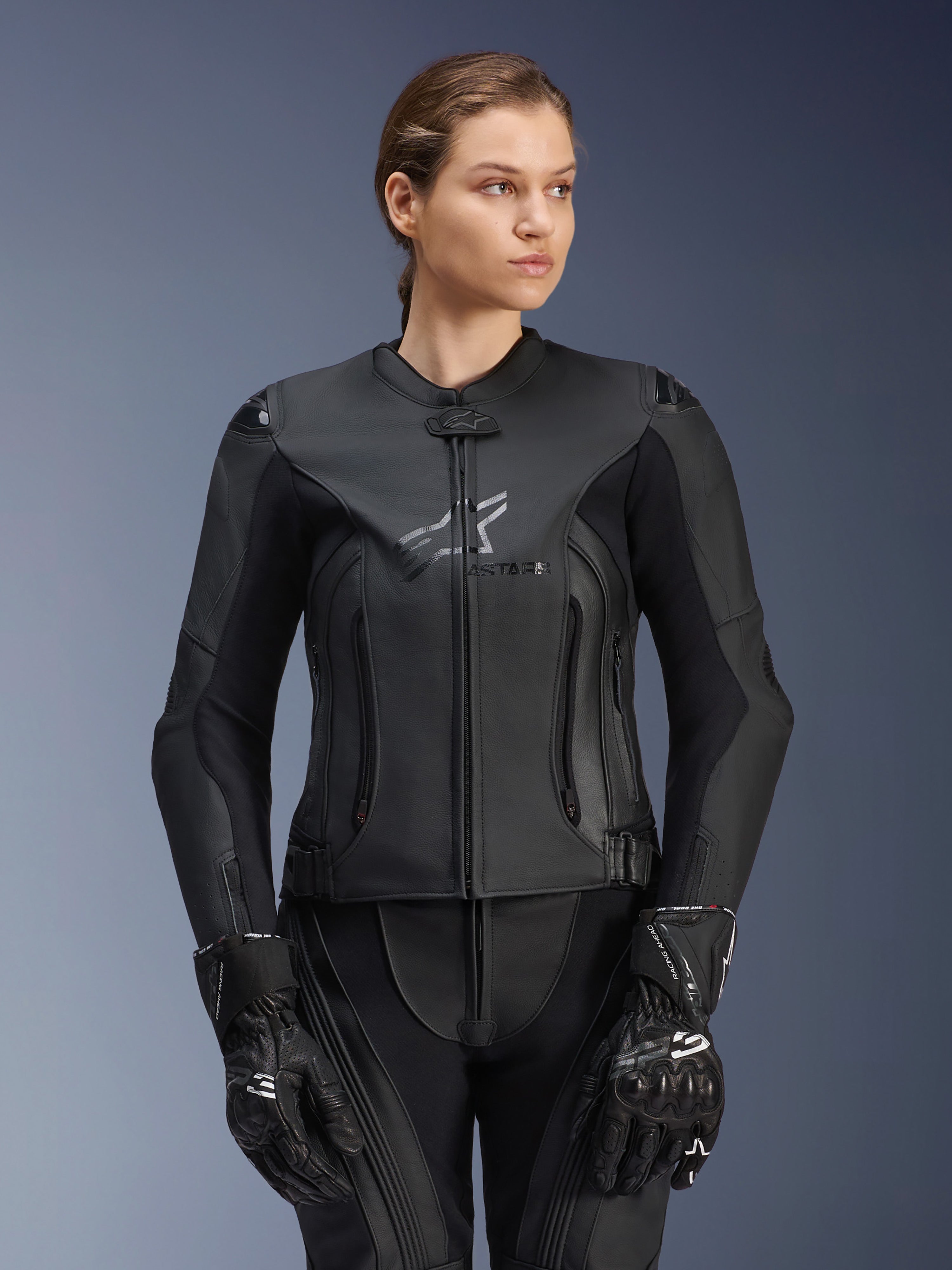 Alpinestars Stella GP Plus V4 læderjakke, sort, motorcykelracingjakke til kvinder, førsteklasses læderkonstruktion med beskyttende polstring, strømlinet design med diskret logo, båret af en kvindelig model med matchende sort udstyr
