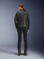Alpinestars Stella Dyno læderjakke set bagfra, kvinde iført sort jakke med Haute Red-detaljer, kombineret med sorte slim-fit bukser og sorte støvler, moderne heritage lædermotorcykeljakke-design