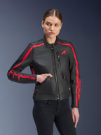 Alpinestars Stella Dyno læderjakke, dame motorcykeljakke, Black Haute Red, båret af en model med sorte jeans, med røde racerstriber på skuldre og ærmer med markant branding, premium læderkonstruktion, heritage-inspireret design til urban kørsel
