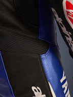 Nærbillede af detajler på Alpinesta rs Yamaha G P-R7 1-delt l æderdragt, metallic blå og sor t, med perfo rere de læ derpaneler ti l ventilation, sorte harmoni k a-st ræk inds atser for fle ksibilitet og markant hvid Ya ma h a-br anding, d er f re mhæv er konstruktion en i bovint l æder af racing-kva litet.